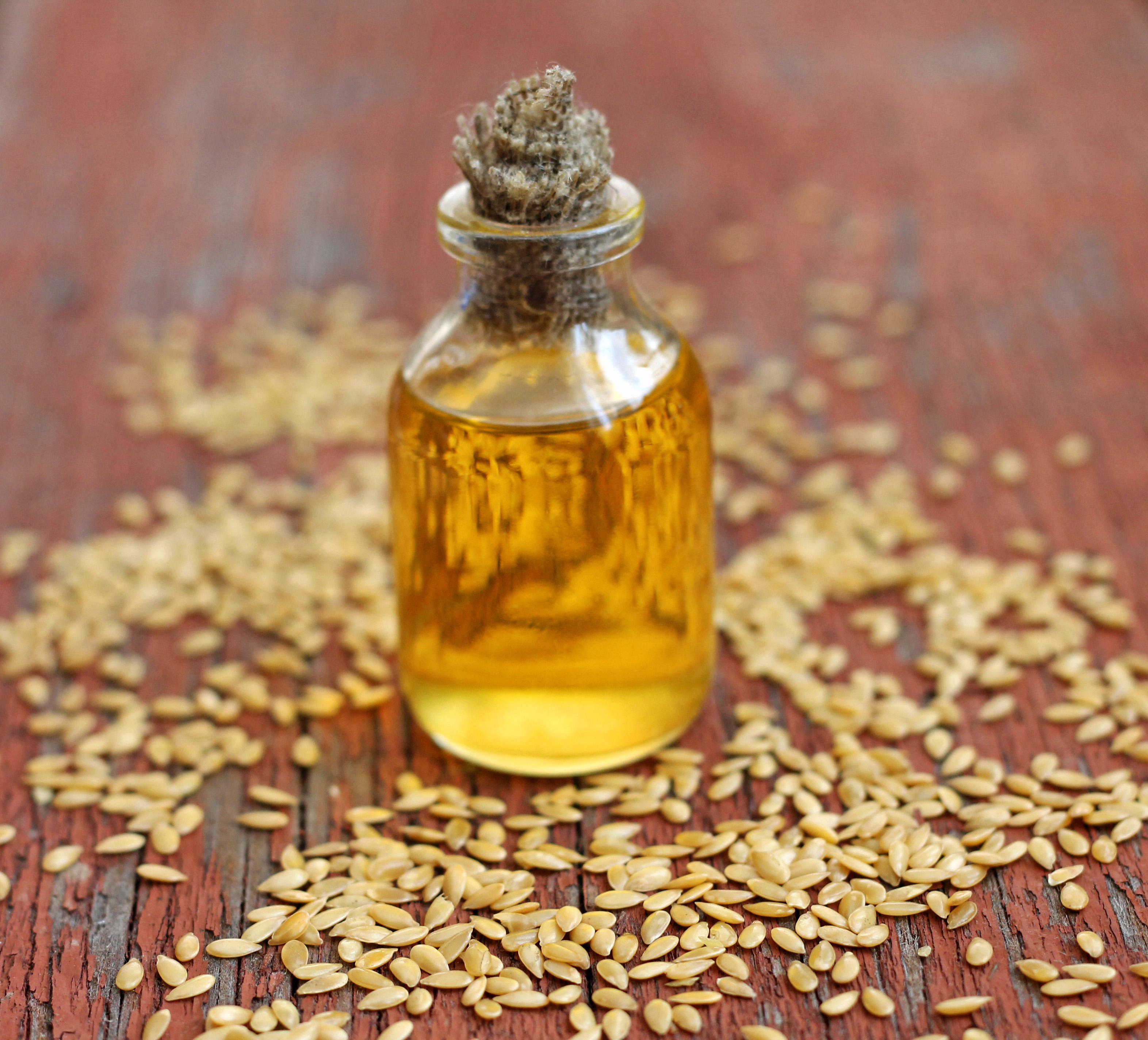 linseed oil in bottle on wooden background, close-up